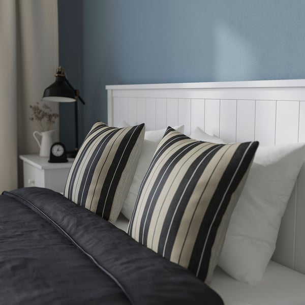 Cosy bedroom scene with GULLABERG bed, striped pillows, and bedside lamp.