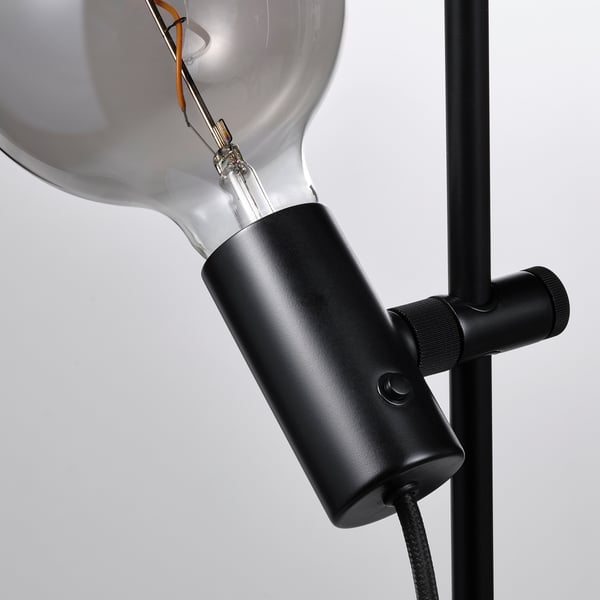 Adjustable floor lamp with vintage led bulb, dark base, metallic accents.