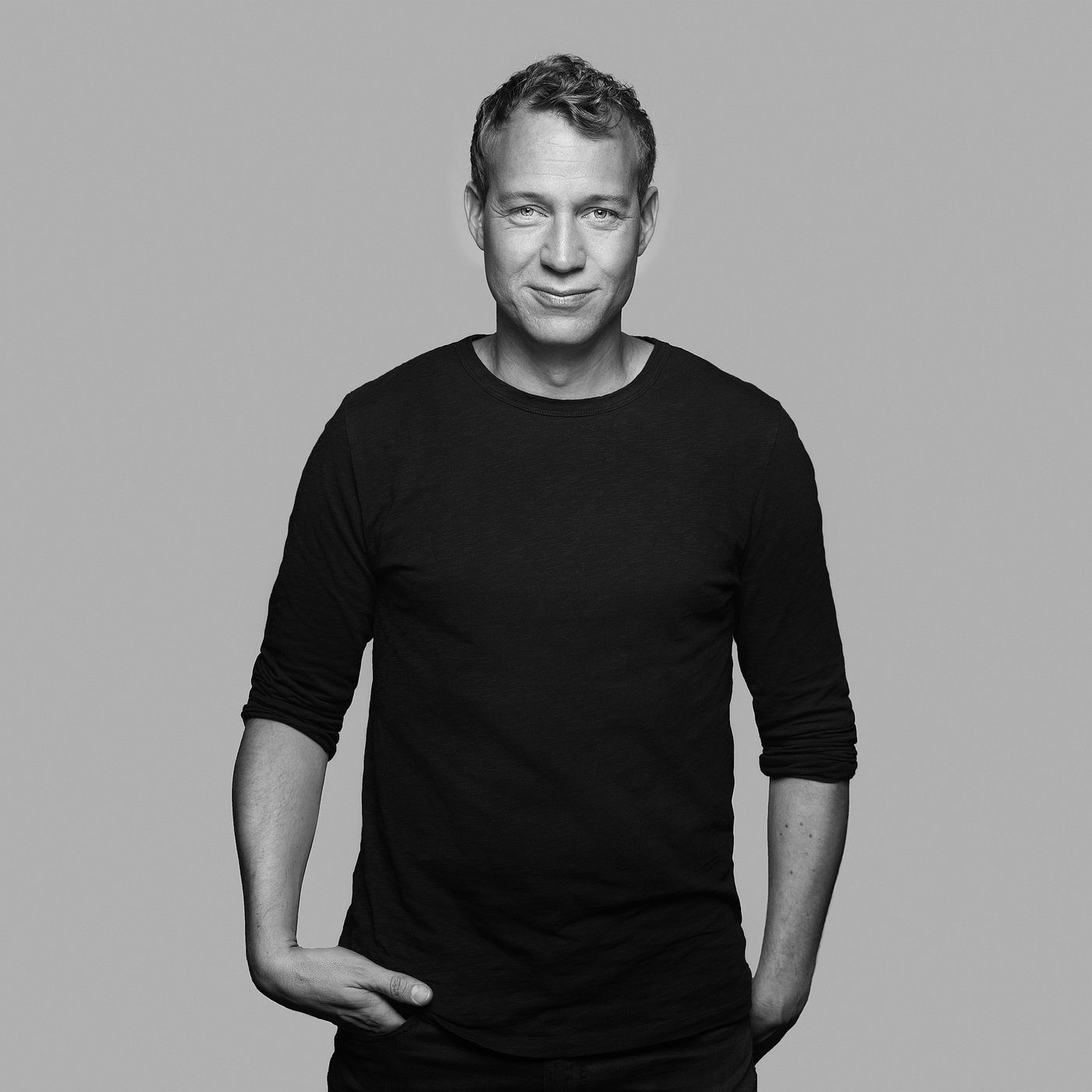 Black and white portrait of David Wahl with short hair wearing a long-sleeve shirt, posing confidently.