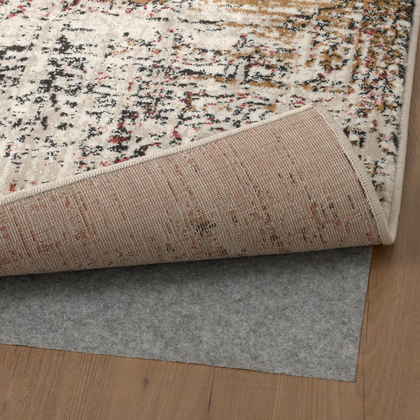 Brown logs, faded rug with folded corner revealing grey backing.