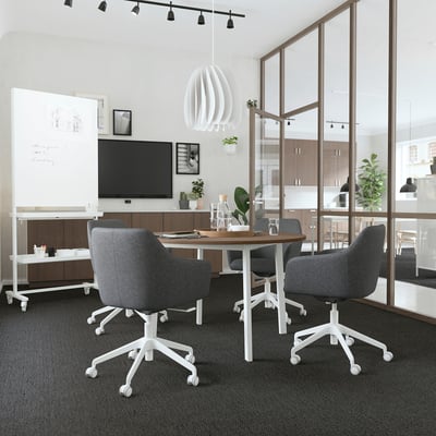 Modern office with MITTZONs round, wooden table and grey chairs. White underframe. Well-lit, sleek design. Small for intimate meetings.