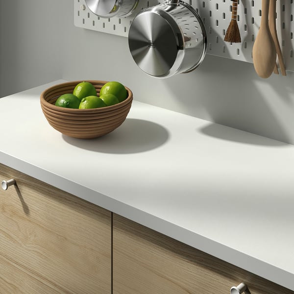 Kitchen counter with a bowl of limes and a hanging pot.