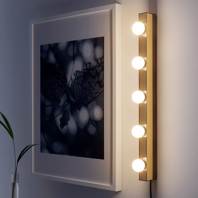 Modern MUSIK wall lamp with five circular lights, warm glow, sleek steel body, ideal for small spaces.