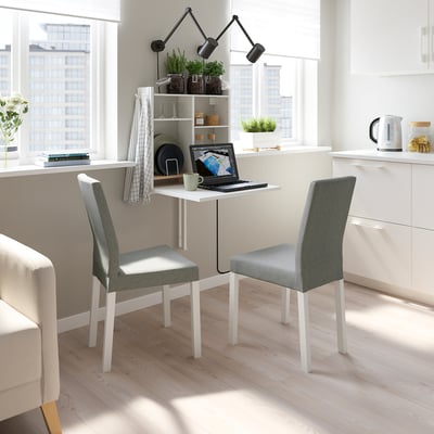 Modern minimalist workspace: white wall-hung table with storage, two grey chairs, large window, city view.