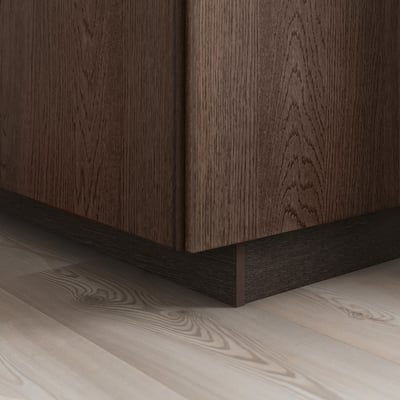 Dark wood cabinet with visible grain, solid oak edging on base, sits on light wooden floor, showcasing SINARP fronts elegance and detail.