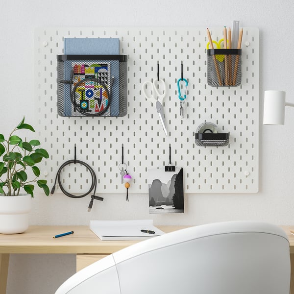 SKÅDIS white pegboard organisers: scissors, pens, plant, desk items; fits well above workspace.