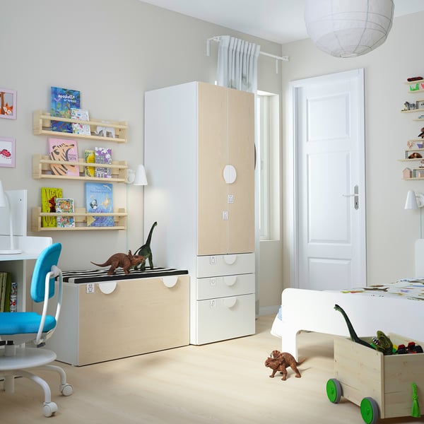 Kids room with wood furniture, colourful books, blue chair, dinosaur toys.