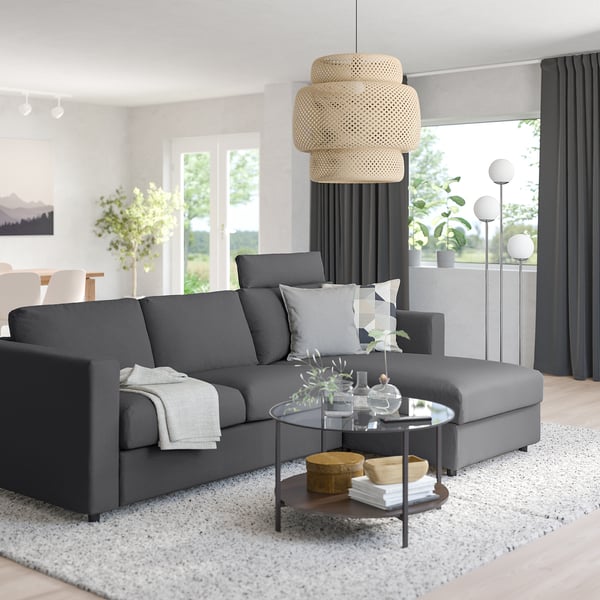 Modern living room: VIMLE sectional, glass table with decor, pendant light, large window, white rug.