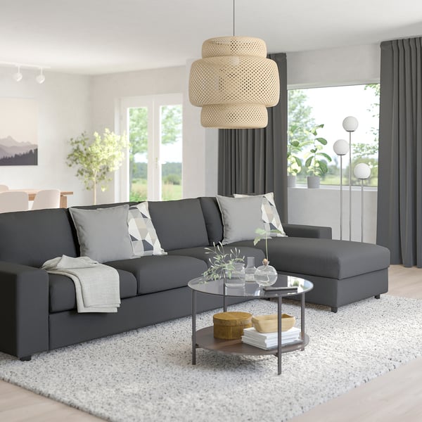 Modern living room with large grey VIMLE sectional sofa, white rug, glass coffee table, and wicker pendant lamp.