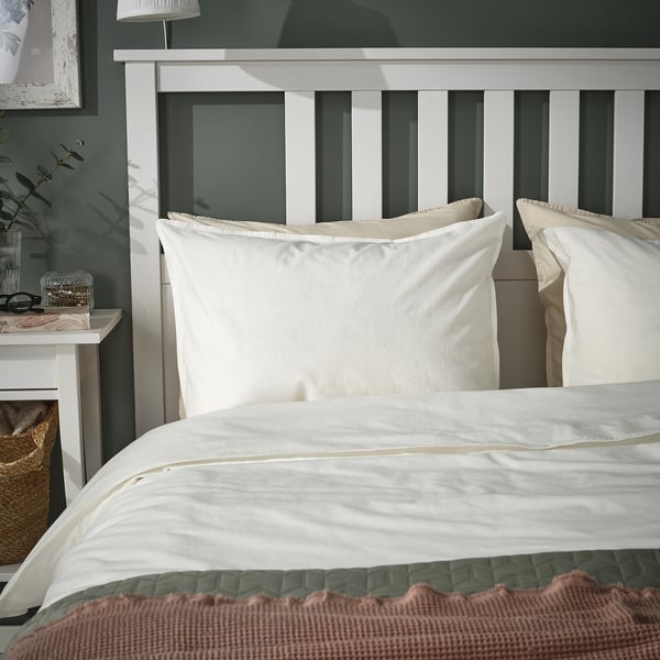 ÄNGSLILJA pillowcases, light beige, soft cotton, rectangular, on bed, with headboard. Neutrally styled, cosy bedroom.
