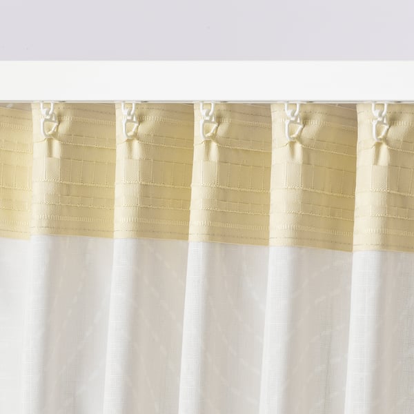 Close-up of light-filtering curtains with a subtle pattern, featuring hooks along the top edge for easy installation.