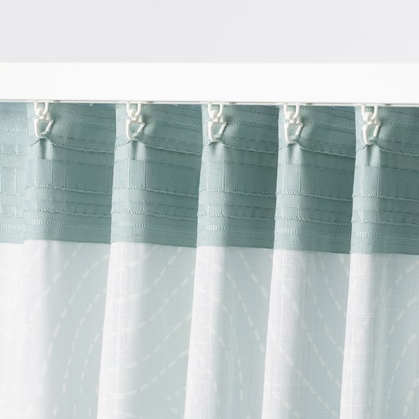 Light blue curtains with white hooks, offering privacy while allowing daylight in.