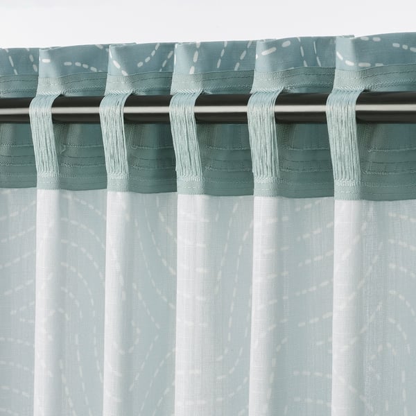 Decorative curtains with a subtle pattern in a soft blue-green colour, featuring a tab top for hanging. They allow light while providing privacy.