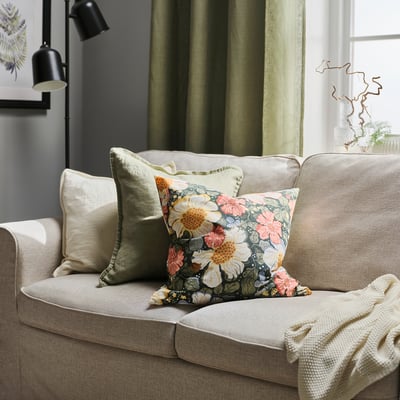Floral cushion cover in cream & multi on beige sofa with zip