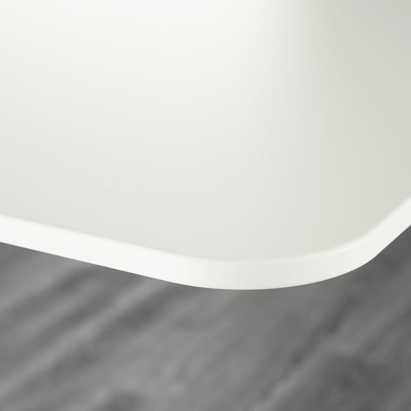 Image shows a modern, pristine white desk with a smooth, round edge. High-quality finish, part of the BEKANT series.
