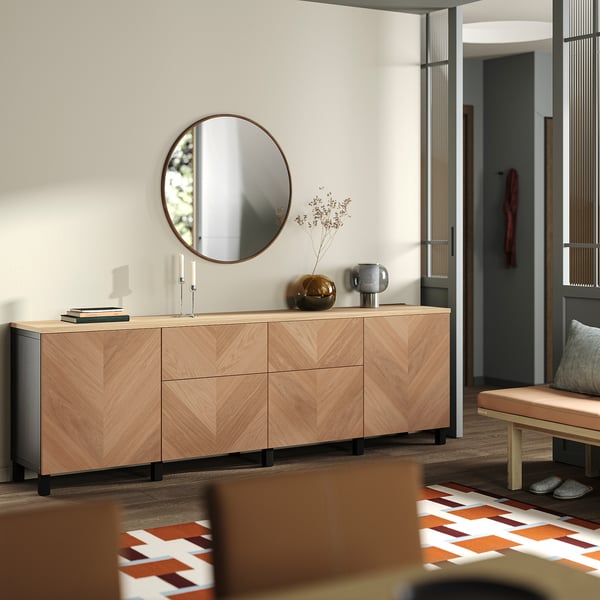 Modern entryway with light wood sideboard, mirror, and bench with rug.