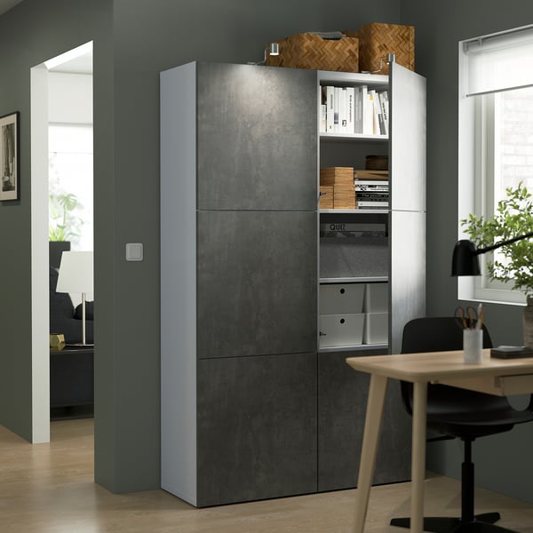 Modern tall storage unit with textured doors and adjustable shelves situated in a home office with a chair and desk.