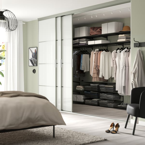Modern bedroom with BOAXEL dark grey steel storage, organised closet, bed, chair, high heels.