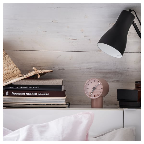 Image a pink BONDTOLVAN alarm clock on a wooden shelf with books and a lamp.