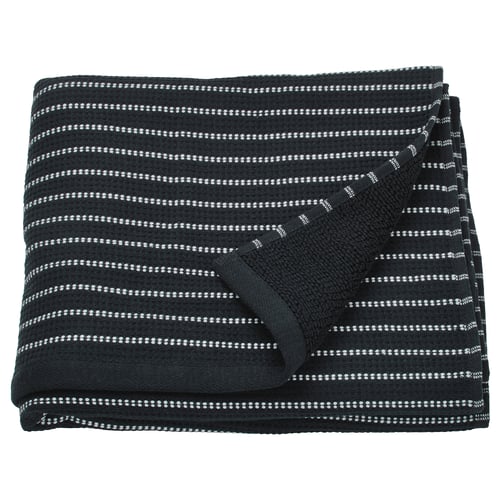 The BROKGINST towel is black with white stripes, made of cotton, rectangular, and folded with visible waffle texture.