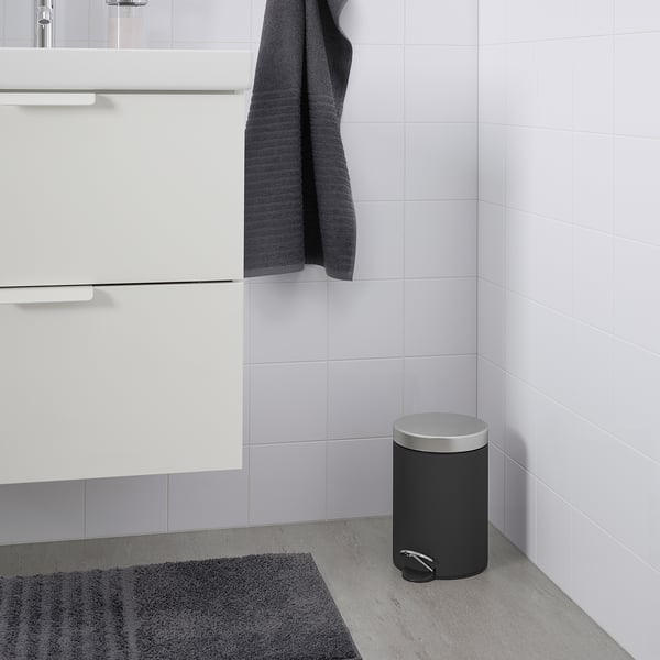 EKOLN grey bin, sleek design, fits small spaces, includes a handle, now near a bathroom sink.