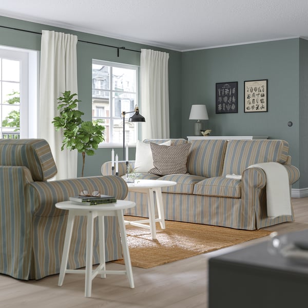 Stylish living room: EKTORP striped sofa, armchair, and side table with lamp. Soft cushions, striped cotton cover. Sofa is large, fits well in room.