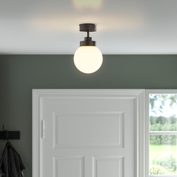 Frosted glass ceiling light above white door for hallways or bathrooms.