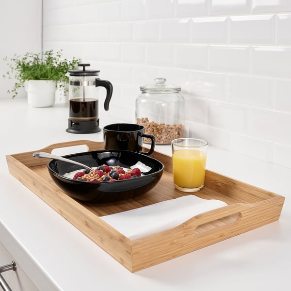 Breakfast tray with handles holds bowl of yoghurt, granola, berries, coffee, and orange juice, perfect for breakfast in bed.