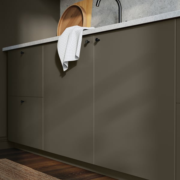 Modern kitchen with dark brown cabinets and hanging white towel. Stainless steel tap and grey countertop.