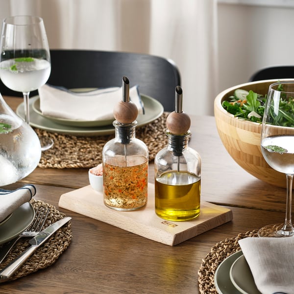 Wooden drip stoppers on glass bottles prevent spills. Set shown with plates, glasses, and salad.