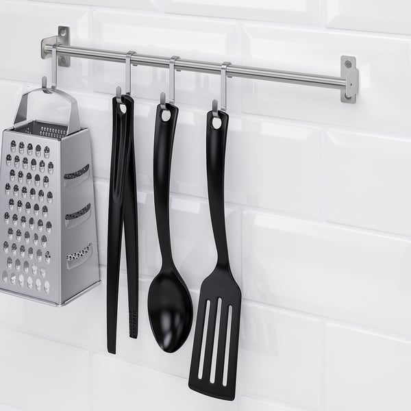 Kitchen tools hung on KUNGSFORS rail against white tiles.