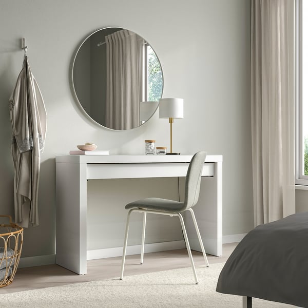 Modern bedroom with MALM dressing table, mirror, chair, and lamp. Curtained window, grey bedspread.