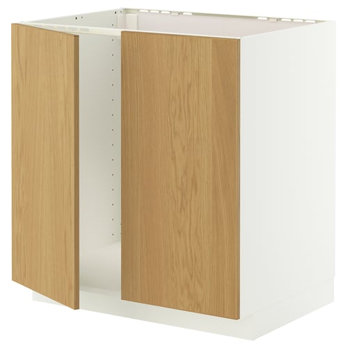 A white METOD cabinet with wooden doors, featuring a sturdy frame and snap-on hinges, designed for a built-in oven or sink.