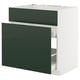 A white METOD kitchen cabinet with green drawers. It has three drawers; the middle drawer is partially open, revealing inner compartments.