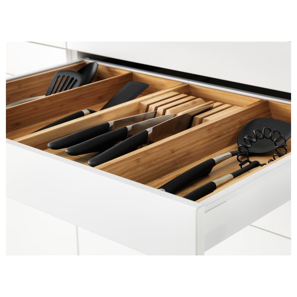 Open kitchen drawer with knife slots and utensils, part of IKEAs METOD system.