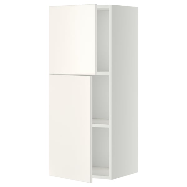 A white METOD kitchen wall cabinet with one door open, revealing an adjustable shelf inside. It has a sleek, modern design.