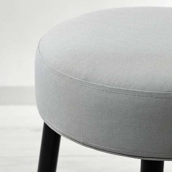 Round upholstered stool with pattern. Sleek black legs, quality fabric. Neutral, minimalist design.