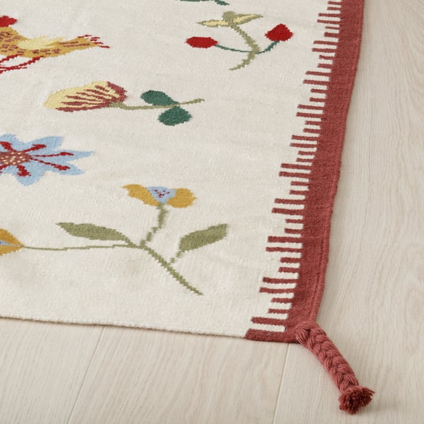 Brightly coloured floral rug with intricate weaving and fringe detail. Vibrant and durable wool and cotton design.