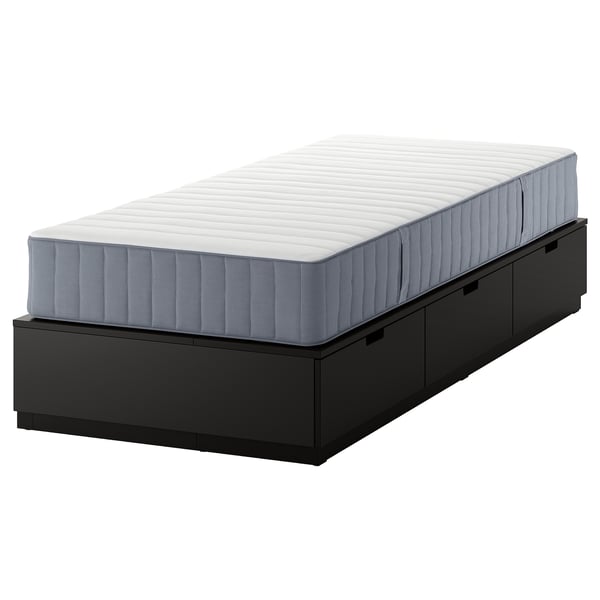 Black NORDLI bed frame with drawers and grey mattress.
