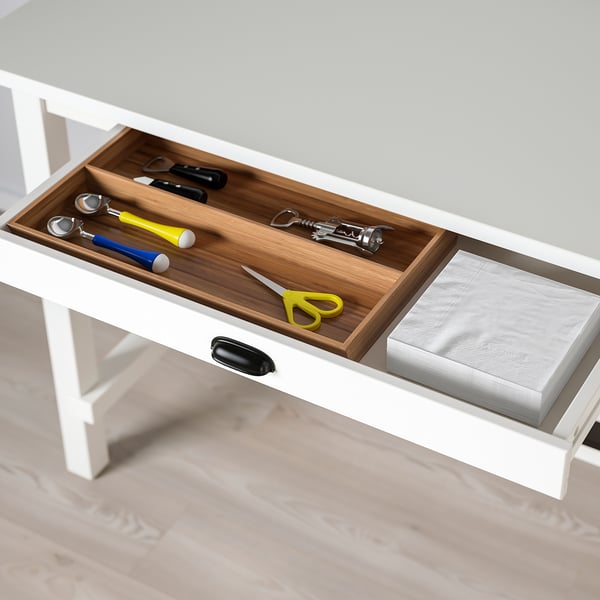 Open drawer of white NORDVIKEN bar table showing kitchen utensils organised in sections.