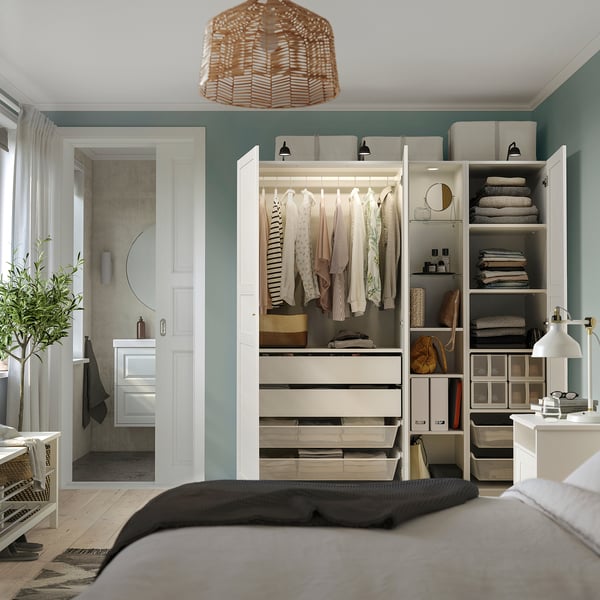 Bedroom with a PAX wardrobe, neatly folded clothes, shelves, and drawers; next to a bathroom with a shower.