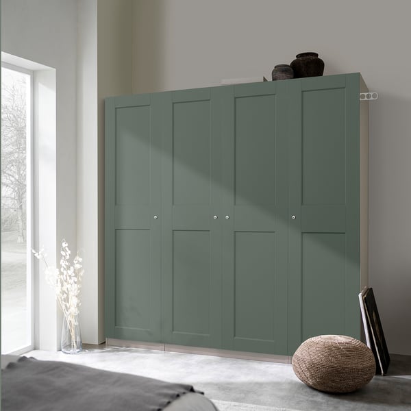 Teal PAX wardrobe next to window in minimalist bedroom with storage and decor.