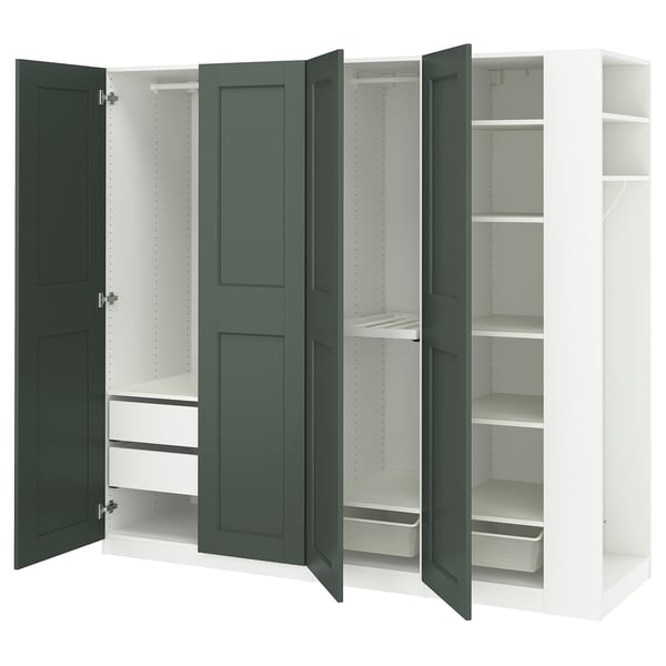 An open IKEA PAX wardrobe with green doors, white interior compartments, shelves, and organisers.