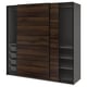 An IKEA PAX wardrobe with dark brown walnut effect sliding doors and black accents. It has three sections: two with shelves and one with drawers.