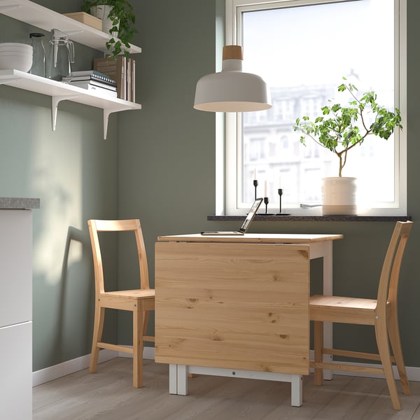 Home office with PINNTORP dining table and chairs. Light wooden furniture, white pendant lamp, green wall, window view.