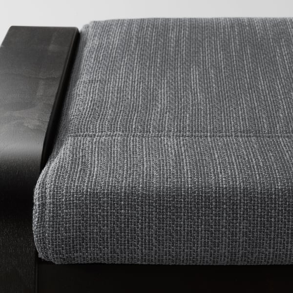 Close-up of a POÄNG footstool showcasing its sturdy frame and plush, textured cushion.