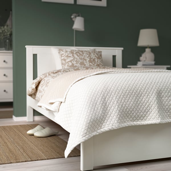 Modern bed, green walls, PRAKTVIAL quilt, nightstand, lamp. Concisely retains the essence of the original.