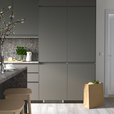 Modern kitchen with sleek, tall grey RÅKALL fridge/freezer. Minimalist design, clean aesthetic.