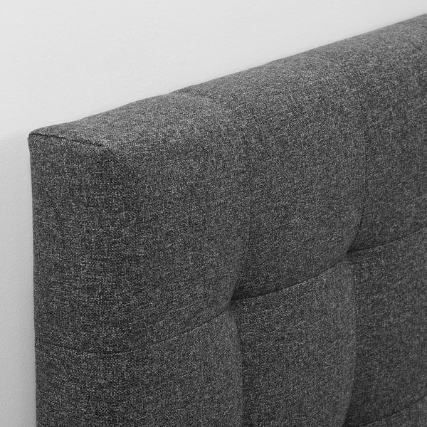 Dark grey upholstered headboard with visible stitching; soft, padded design.