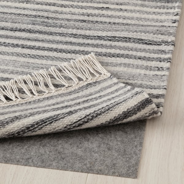 Striped grey wool rug with fringes, perfect for warm floors.